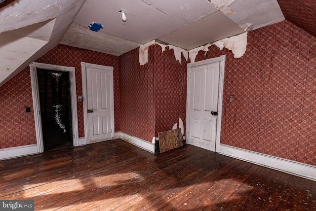 bonus room with dark hardwood / wood-style flooring and vaulted ceiling