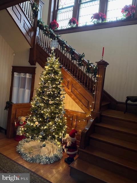 staircase with a towering ceiling and hardwood / wood-style floors