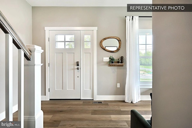 foyer with visible vents, baseboards, and wood finished floors