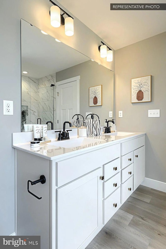 bathroom with a shower with shower door, vanity, and wood-type flooring