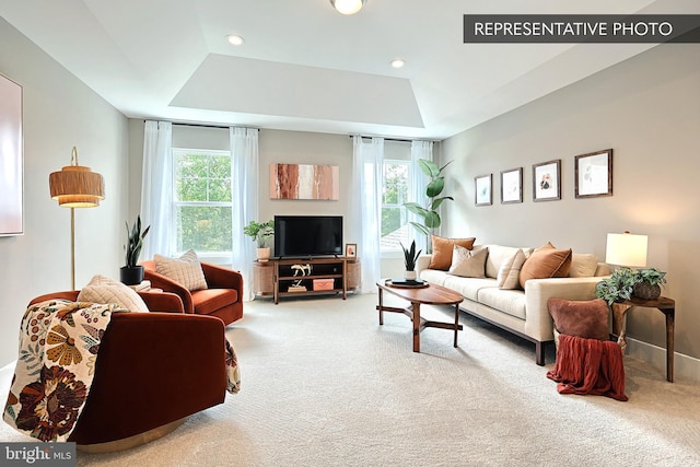 carpeted living room with recessed lighting, a healthy amount of sunlight, and a tray ceiling