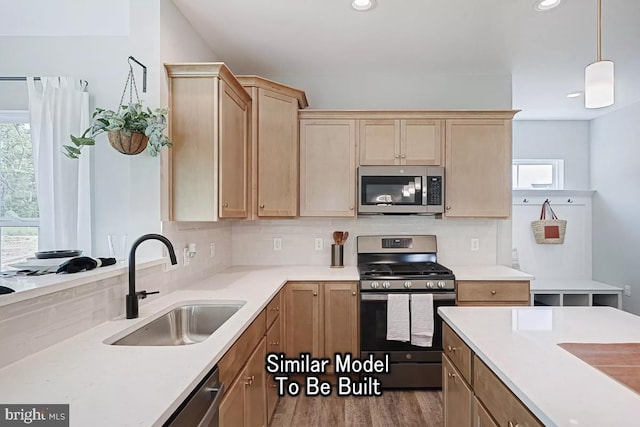 kitchen featuring light hardwood / wood-style floors, appliances with stainless steel finishes, decorative backsplash, hanging light fixtures, and sink