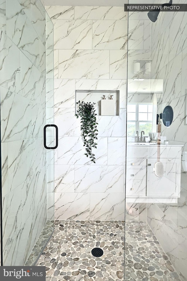 bathroom featuring a marble finish shower