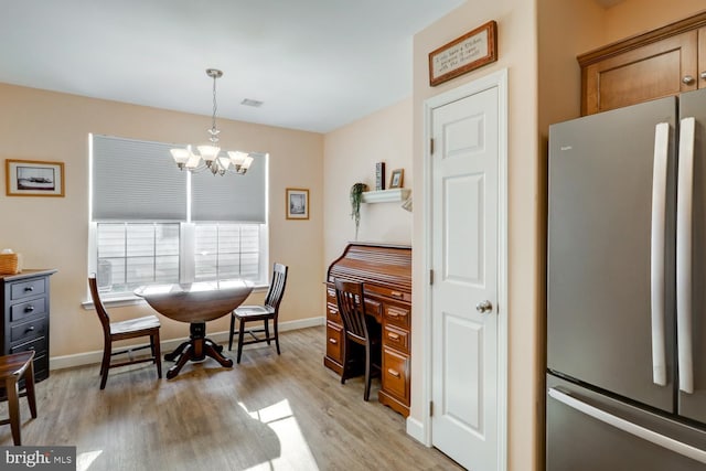 dining room featuring a notable chandelier and light wood-type flooring