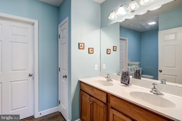 bathroom featuring hardwood / wood-style floors, vanity, and toilet