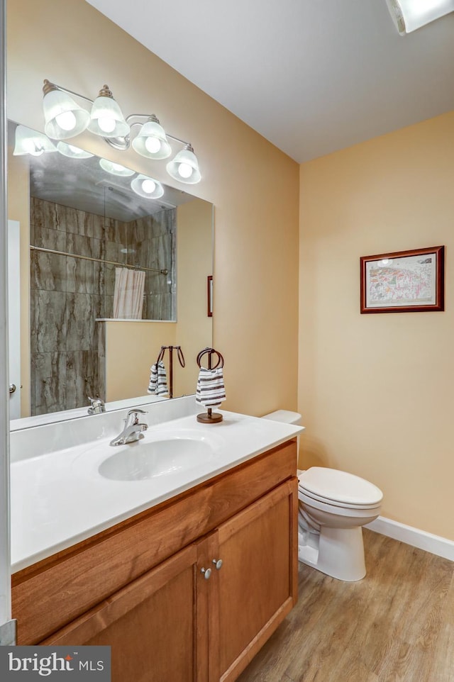 bathroom with curtained shower, vanity, toilet, and hardwood / wood-style flooring