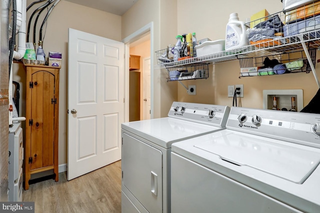 laundry area featuring washer and dryer and light hardwood / wood-style flooring