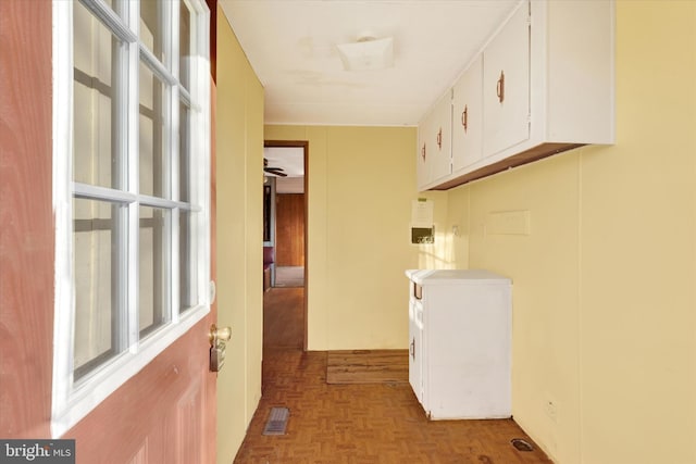 washroom featuring ceiling fan, cabinets, and parquet flooring