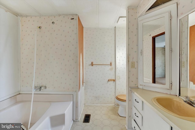 bathroom featuring toilet, vanity, and a washtub