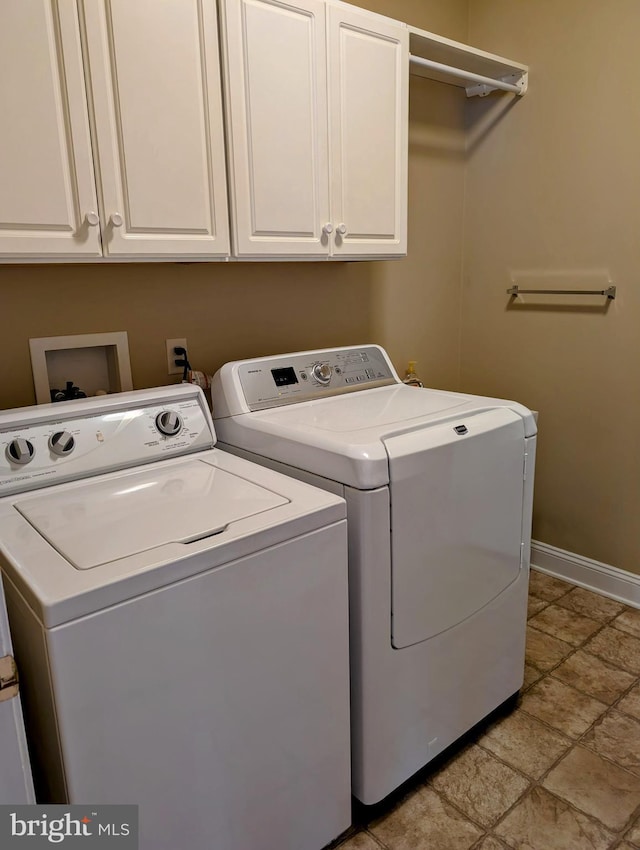 washroom featuring washing machine and dryer and cabinets