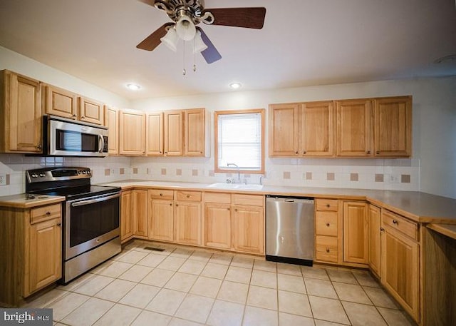 kitchen with sink, ceiling fan, light tile patterned floors, tasteful backsplash, and stainless steel appliances