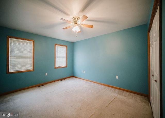 unfurnished room with ceiling fan and light carpet