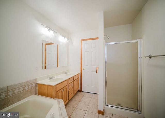 bathroom with tile patterned floors, vanity, and shower with separate bathtub