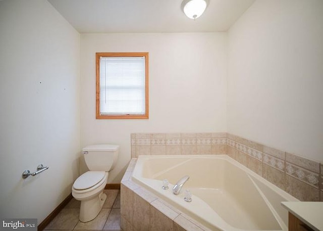 bathroom with tile patterned floors, vanity, a relaxing tiled tub, and toilet