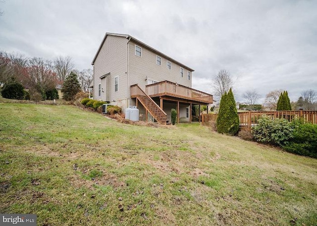 back of property featuring a lawn and a wooden deck