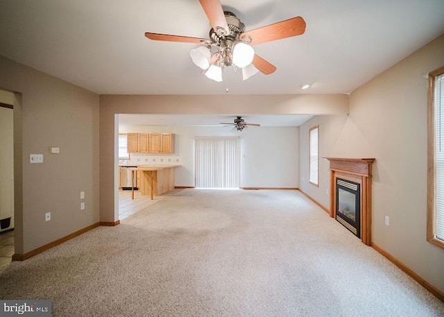 unfurnished living room featuring ceiling fan and light colored carpet