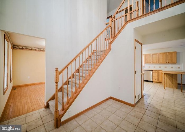 stairs featuring tile patterned floors and a high ceiling