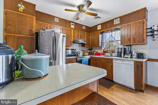 kitchen featuring light wood-type flooring, appliances with stainless steel finishes, ceiling fan, and sink