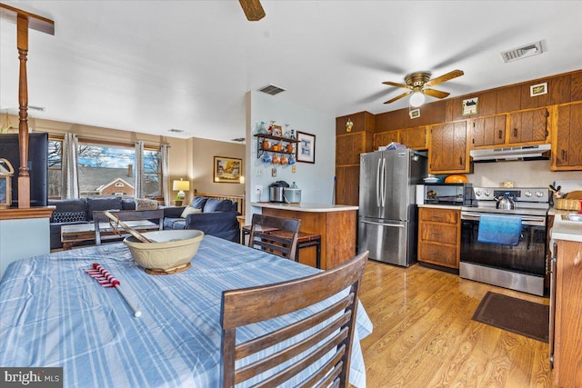 kitchen featuring ceiling fan, stainless steel appliances, and light wood-type flooring