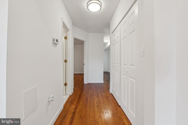 corridor with dark hardwood / wood-style flooring