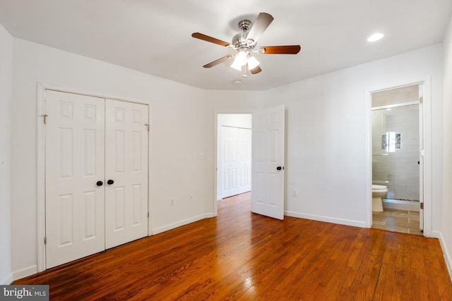 unfurnished bedroom with hardwood / wood-style flooring, ceiling fan, ensuite bathroom, and a closet