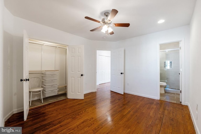 unfurnished bedroom featuring dark wood-type flooring, ensuite bath, ceiling fan, and a closet