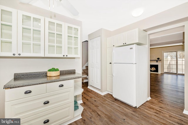 kitchen with white cabinets, white refrigerator, ceiling fan, and dark wood-type flooring