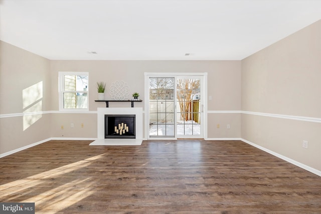 unfurnished living room featuring dark hardwood / wood-style flooring and a wealth of natural light