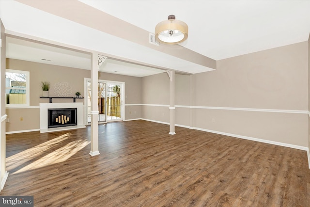 unfurnished living room with dark hardwood / wood-style floors and plenty of natural light