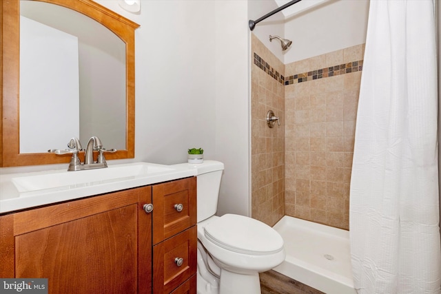 bathroom featuring toilet, walk in shower, and vanity