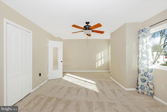 carpeted spare room with ceiling fan