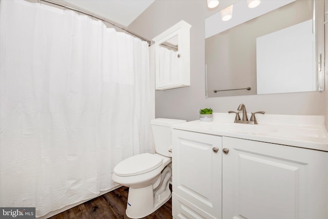 bathroom featuring toilet, vanity, and hardwood / wood-style floors