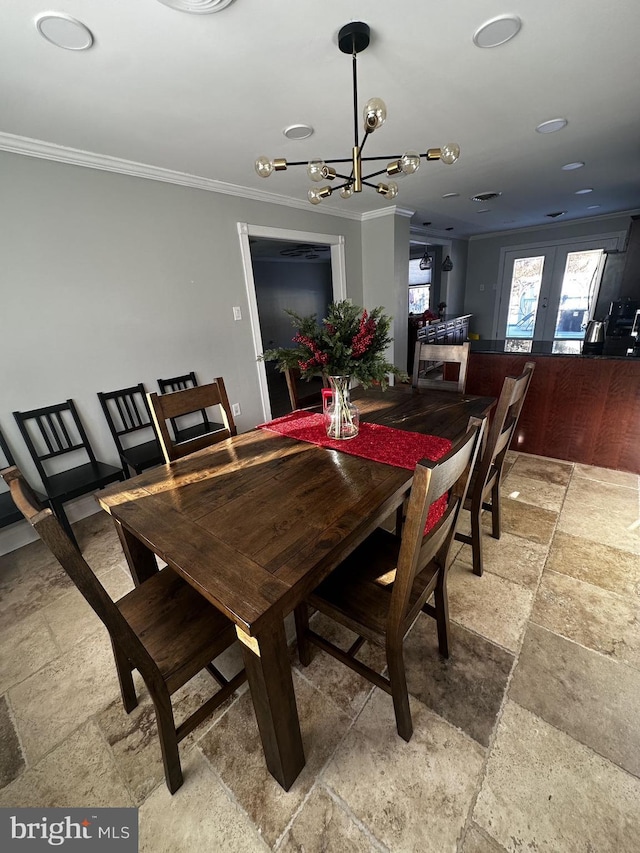 dining room featuring an inviting chandelier, ornamental molding, and french doors