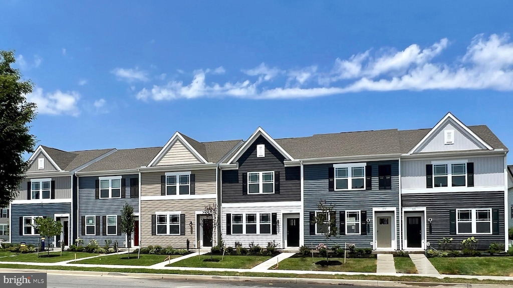 townhome / multi-family property featuring a front lawn