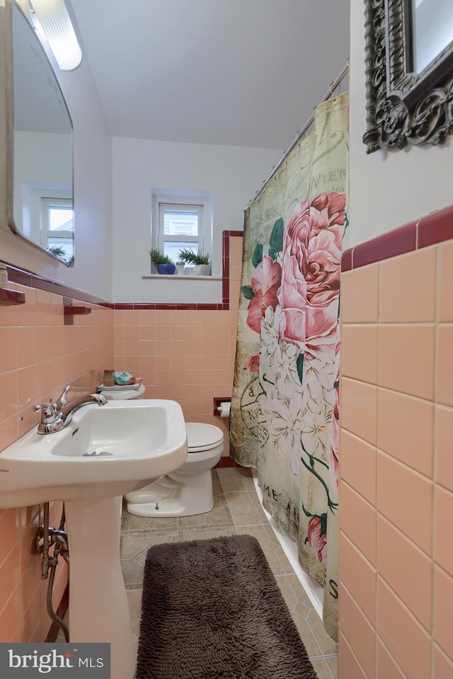 bathroom featuring tile walls, toilet, tile patterned floors, and a shower with shower curtain