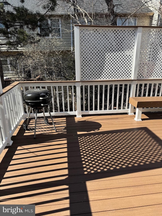 wooden deck featuring a grill