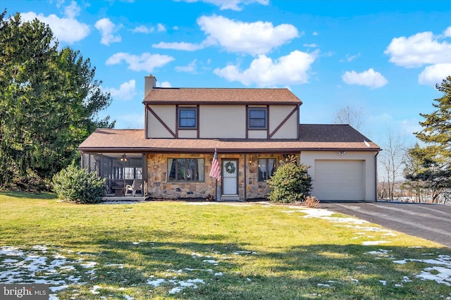 english style home with a garage and a front lawn