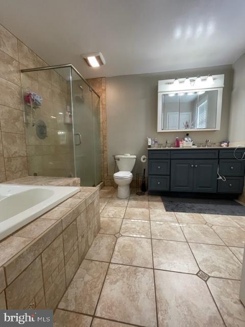 full bathroom with tile patterned flooring, vanity, separate shower and tub, and toilet