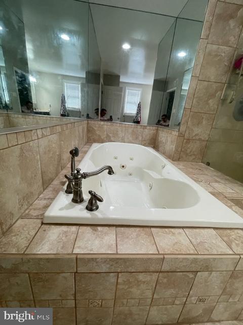 bathroom featuring a relaxing tiled tub