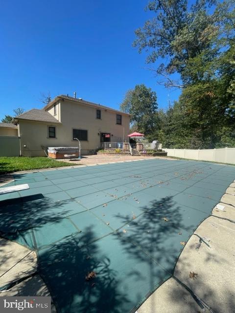 view of swimming pool featuring a patio area and a hot tub