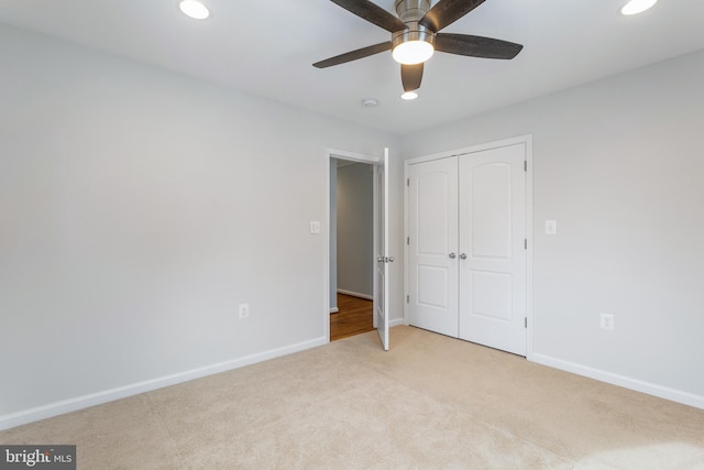 unfurnished bedroom with a closet, ceiling fan, and light carpet