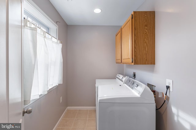 laundry area with light tile patterned floors, cabinets, and washer and dryer