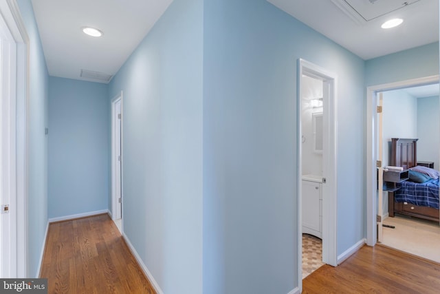 corridor with hardwood / wood-style flooring