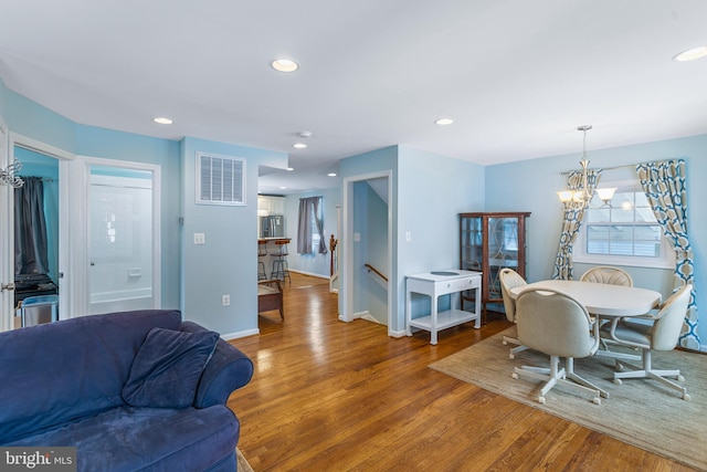 dining space with hardwood / wood-style floors and a chandelier