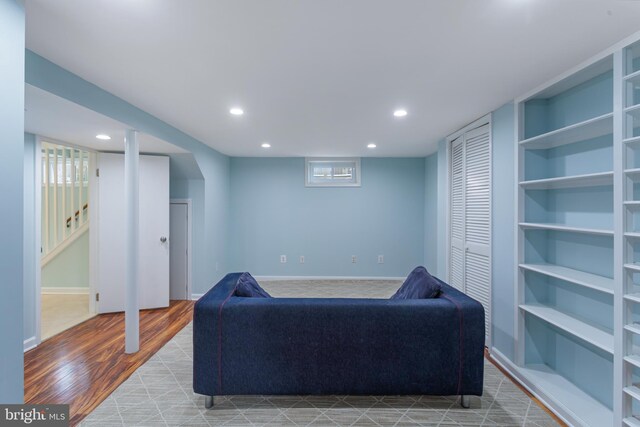 living room with built in features and light hardwood / wood-style flooring