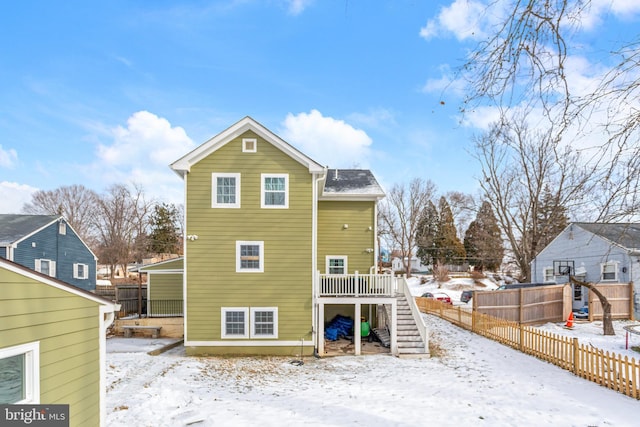 snow covered house featuring a deck