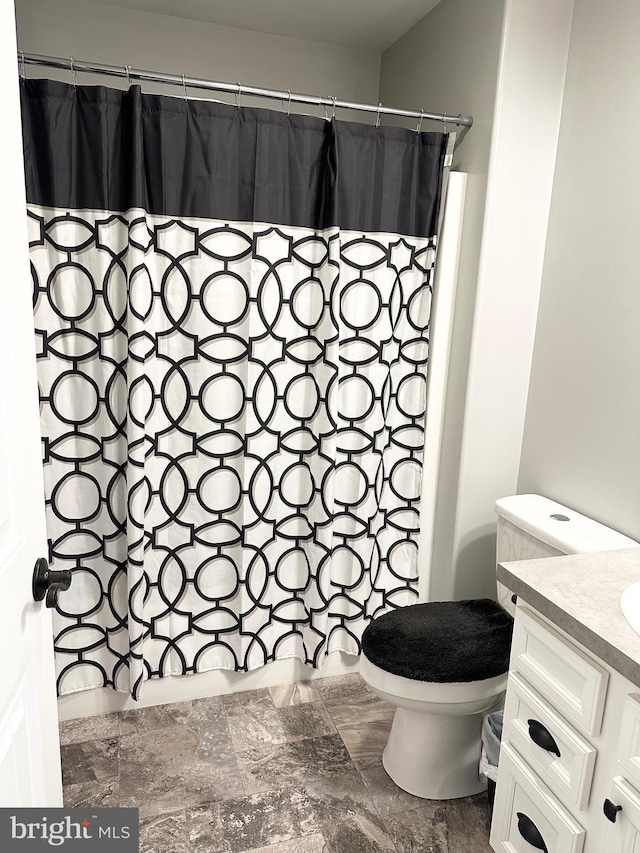 bathroom with toilet, curtained shower, and vanity