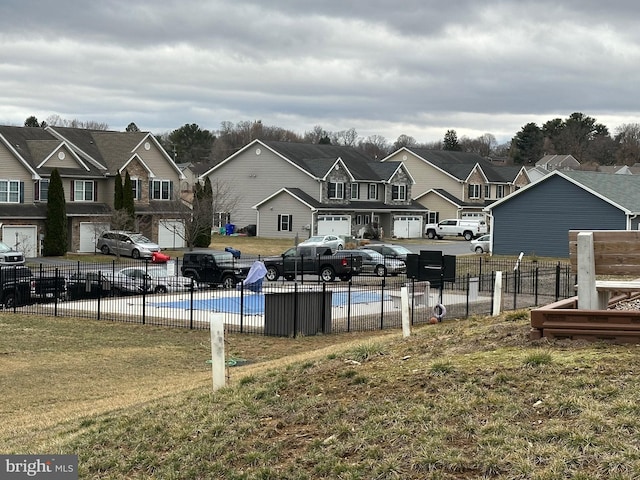 view of yard featuring a residential view, fence, and a fenced in pool