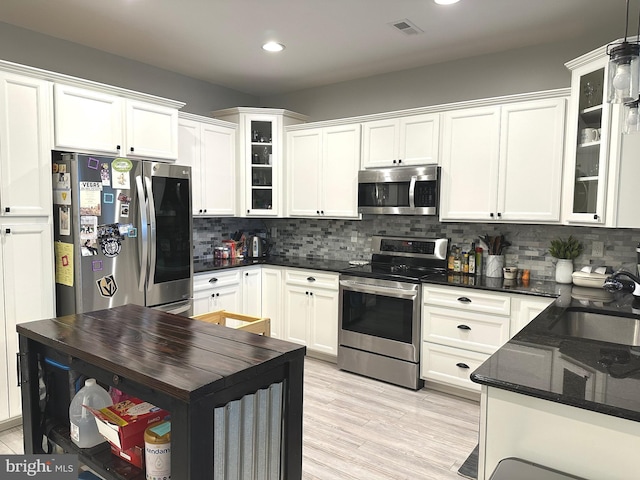 kitchen featuring appliances with stainless steel finishes, visible vents, a sink, and decorative backsplash