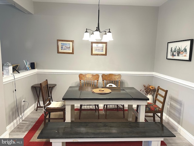 dining room with baseboards, an inviting chandelier, and wood finished floors